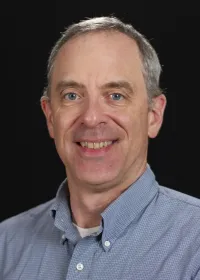 man wearing blue shirt with black background